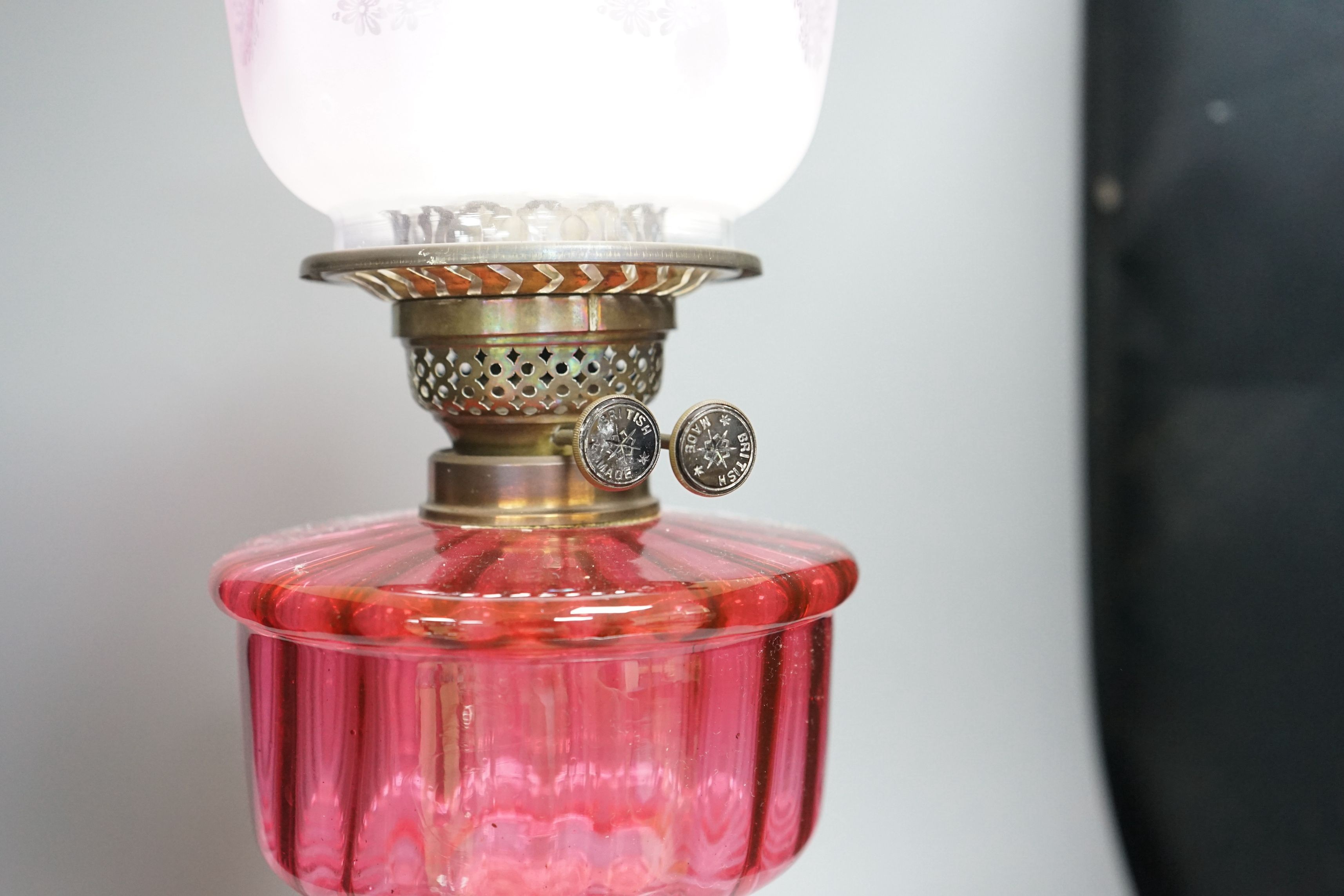 A 19th century cranberry and brass oil lamp with original cranberry shade, height 65cms including glass funnel